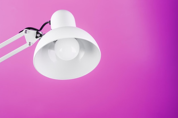 White table office lamp on pink background with space for text and idea concept