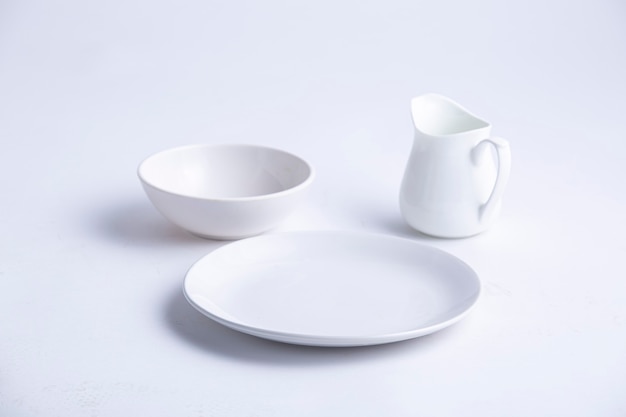 White Table wares different shapes of an empty white ceramic plate bowl and teapot