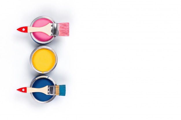 White table with three colored paint jars and brushes.