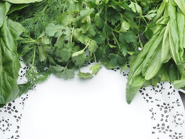 A white table with a white tablecloth with a bunch of fresh herbs on it.