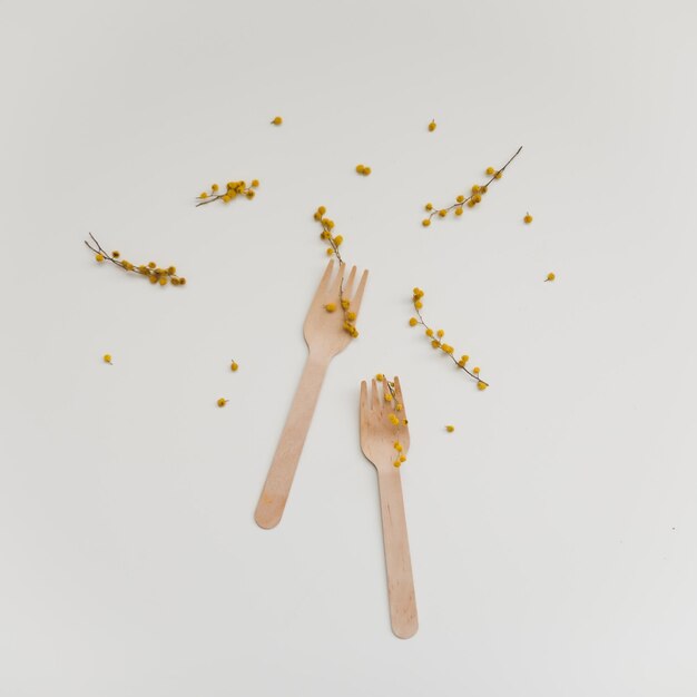 Photo a white table with wooden forks and a bunch of seeds on it.