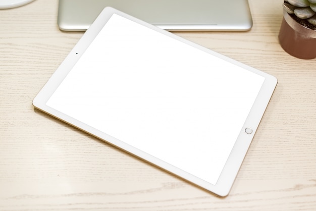 Photo white tablet on white wooden board