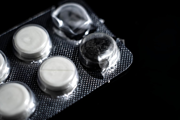 White tablets close up on a black background macro photo