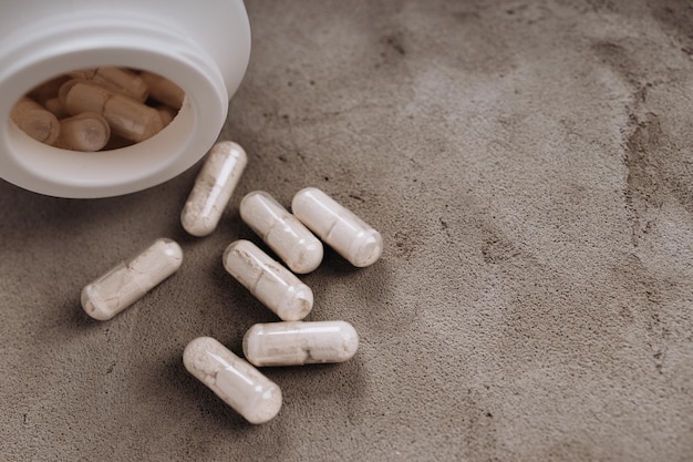 White tablets scattered in front of bottle of pills