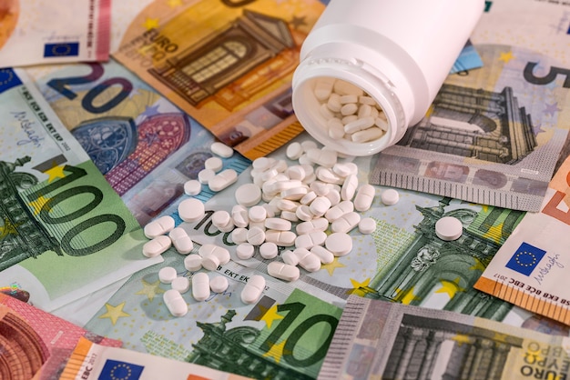 ユーロ紙幣のコンテナと白い錠剤