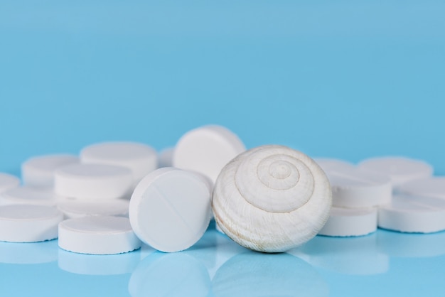 White tablets with a shell on a blue background.