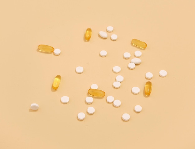 White tablets and yellow capsules to cure diseases Medicine concept