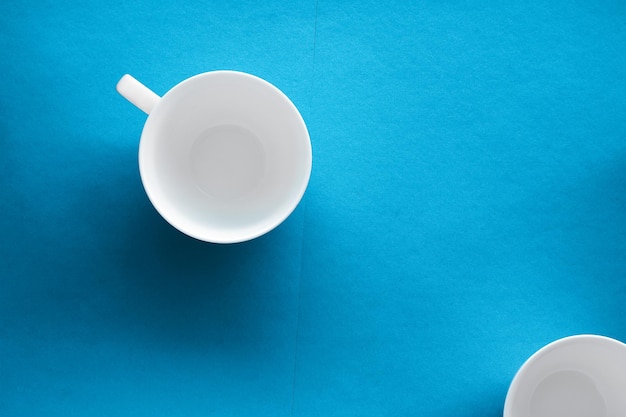 White tableware crockery set empty cup on blue flatlay
background