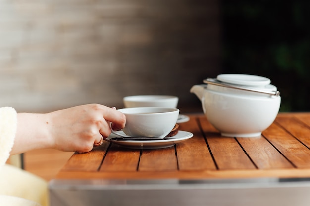 white tableware, large kettle, Cup, bowl, porcelain spoon on a gray gradient background