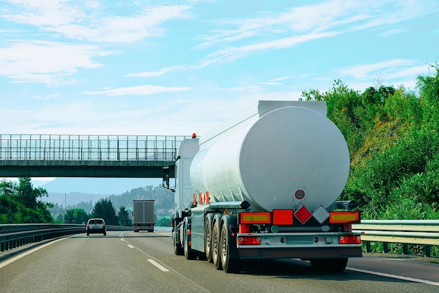 Photo white tanker storage truck in the asphalt highway in poland. business industrial concept.