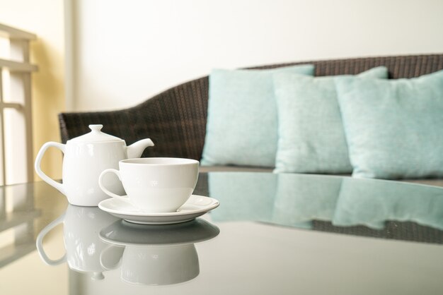 white tea cup with teapot on table