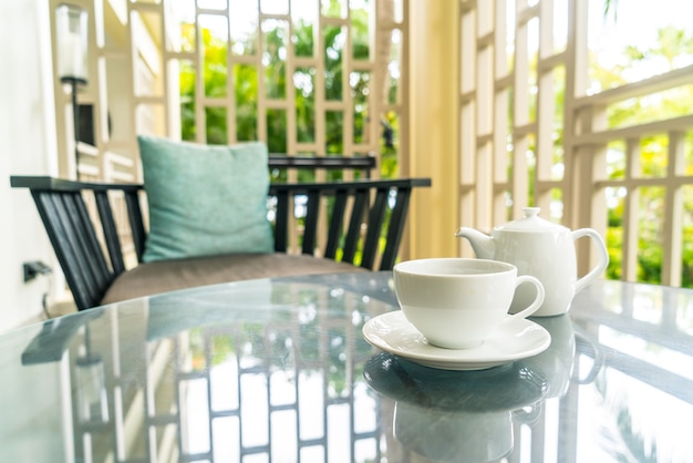 white tea cup with teapot on table