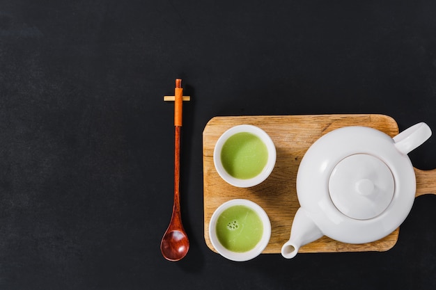 White tea set on wooden cutting board, top view