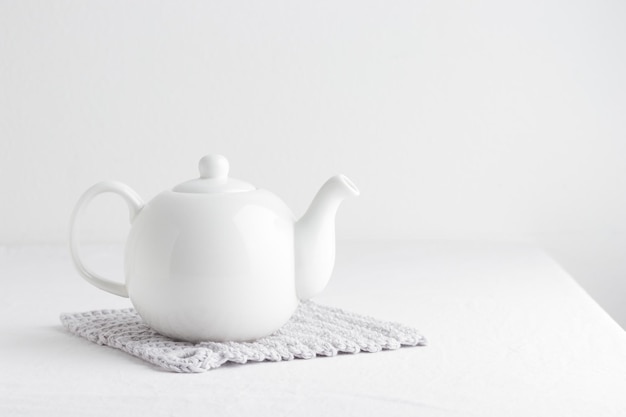 White teapot on a table on a white background