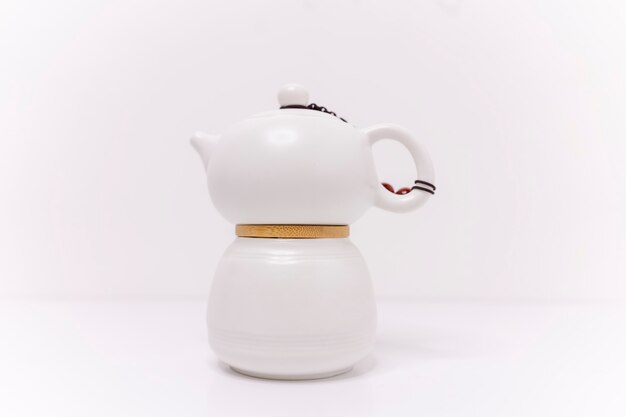 Teiera bianca di tè su una superficie bianca. con copia spazio. prima colazione con tè caldo delizioso.