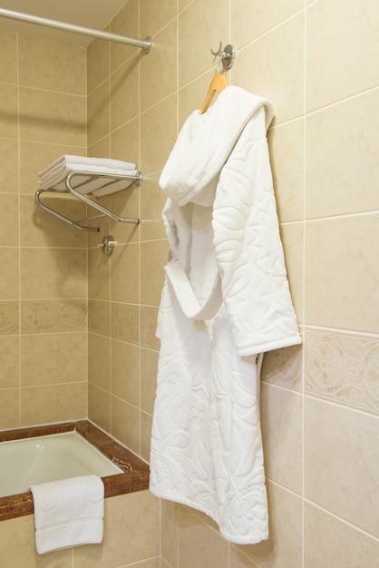 White terry bathrobe hanging in the hotel bathroom