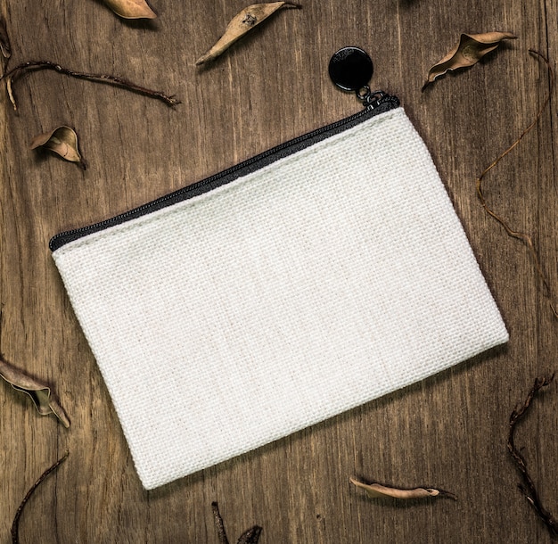 White textile bag on wooden background.