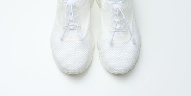white textile sneakers on a white background top view