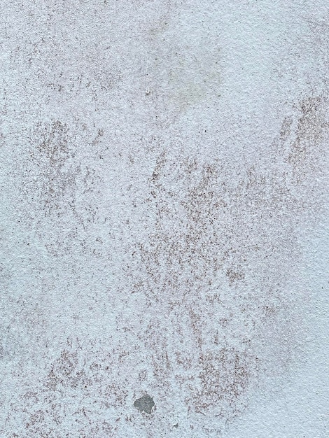 A white textured wall with a rough textured surface.