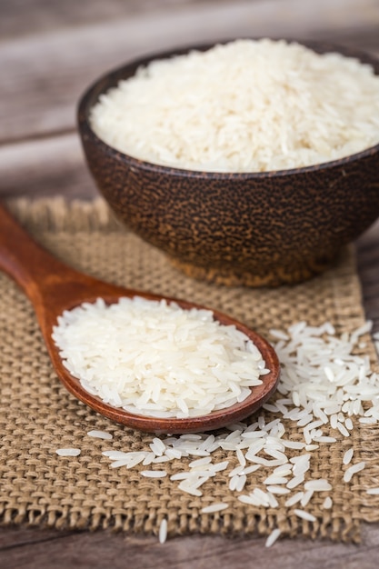 White Thai jasmine rice on wooden plank background