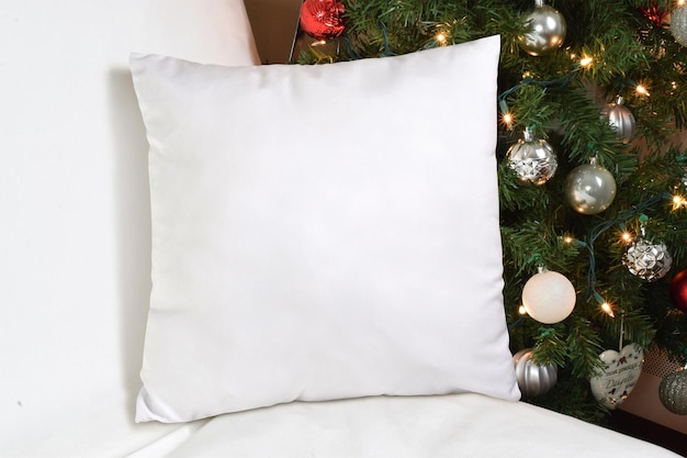 white throw pillow mockup with lit up christmas tree