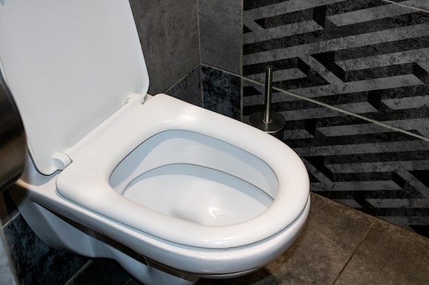Белый туалет и серая плитка крупным планом