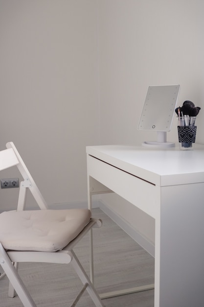거울이있는 흰색 변기 테이블 옷장과 현대적인 실내 공간의 흰색 표면에 메이크업 브러쉬