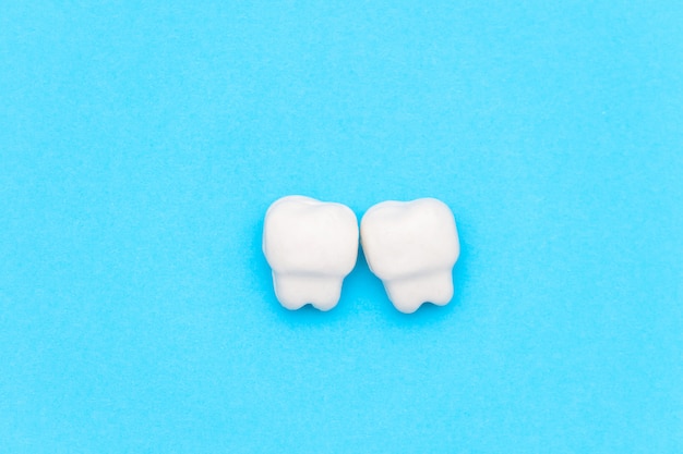 White tooth, space for text on color blue background. Healthy dental teeth concept.