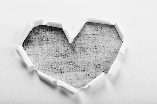 Photo white torn paper heart over textured background