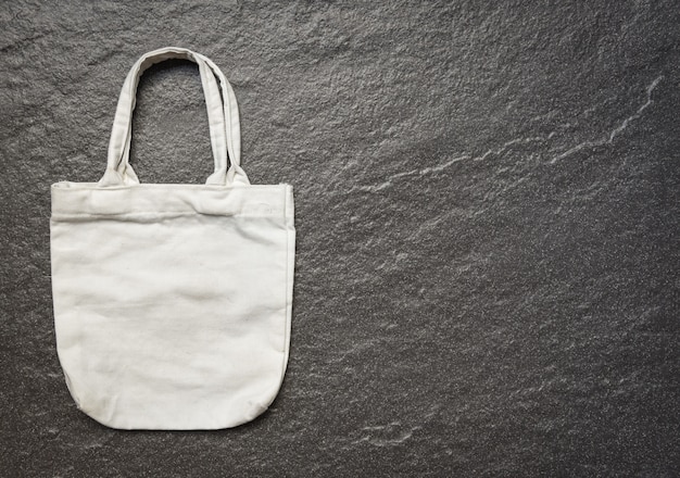 White tote canvas fabric eco bag cloth shopping sack on dark background 