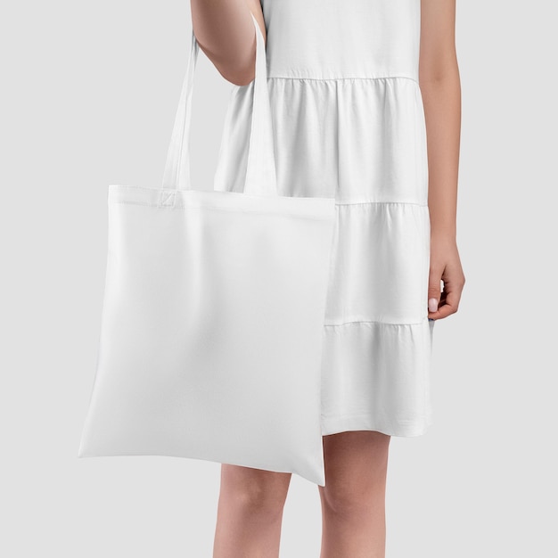 Белая сумка на девушке в сарафане крупным планом, изолированная на заднем плане