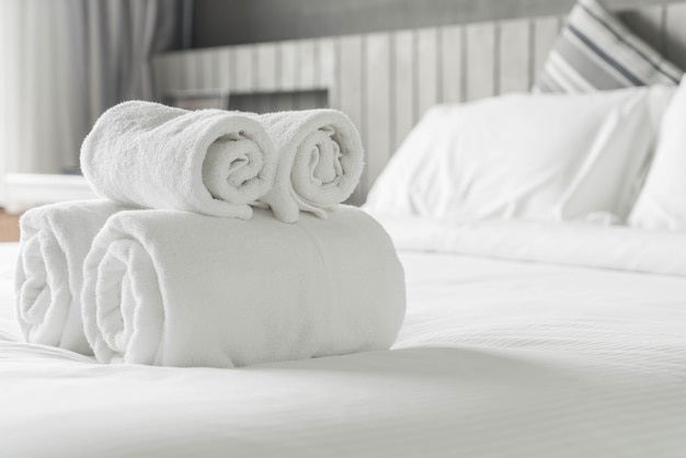 寝室のインテリアのベッドの装飾の上に白いタオル