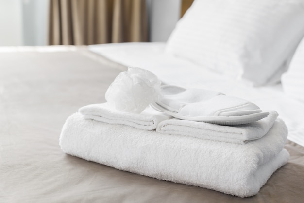 Photo white towel on bed in guest room for hotel customer