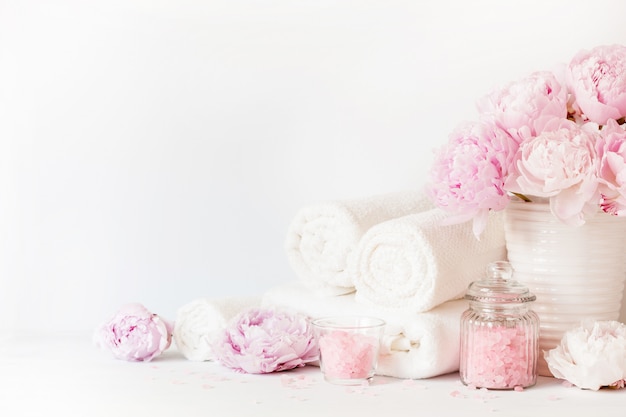 White towels and a vase with peonies