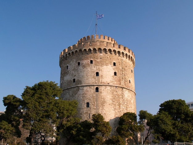 A white tower with a blue flag on it