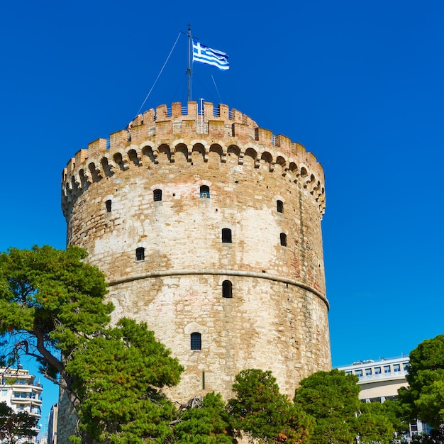 The White tower with Greek flag in Thessaloniki, Greece