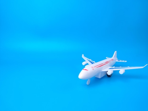 White toy airplane on a blue background with copy space