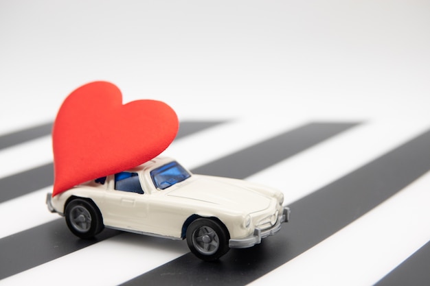 Photo white toy car with a big red heart