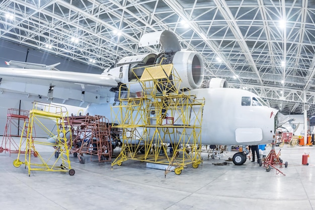 格納庫の白い輸送機。整備中の飛行機