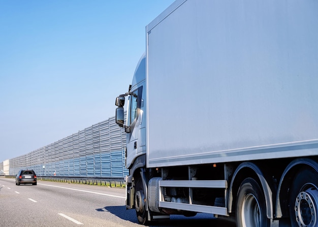 White Truck in the asphalt road of Poland. Lorry transport delivering some freight cargo.