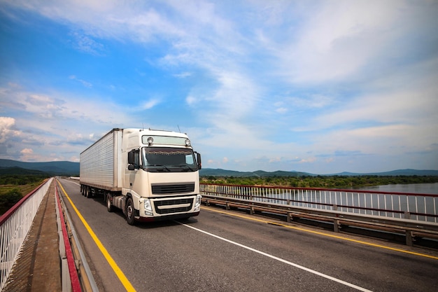 White truck on a bridge in summer.