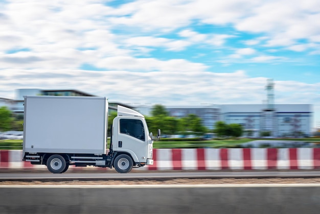 道路を運転する白いトラック。