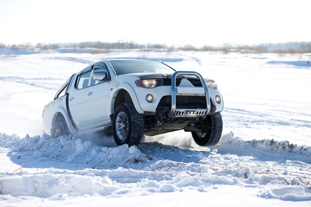 White truck traveling in the snow