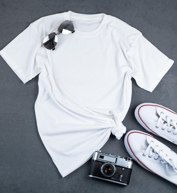Белая футболка с местом для текста Кроссовки очки камера комплект одежды для прогулок Макет футболки для печати Стильный комплект Серый фон с копией пространства