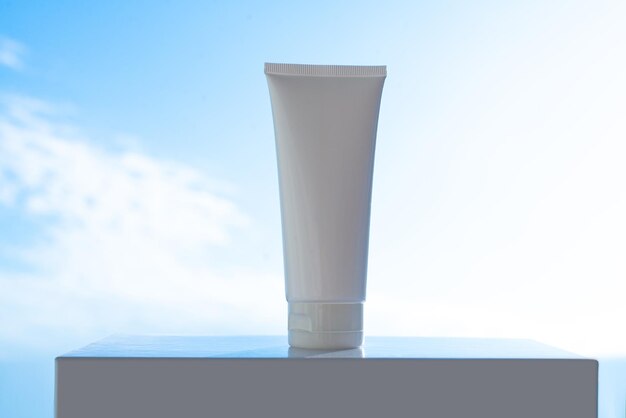 White tube of hand cream on a pedestal against the sky