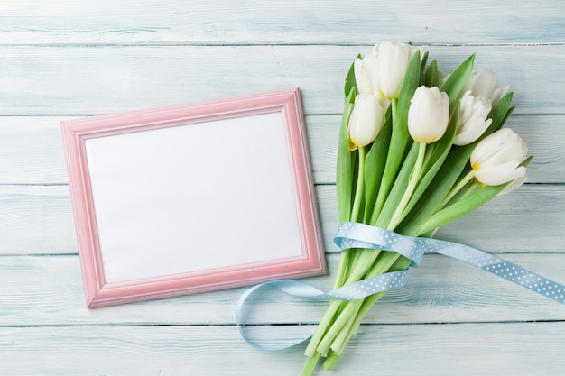 White tulips bouquet and blank photo frame