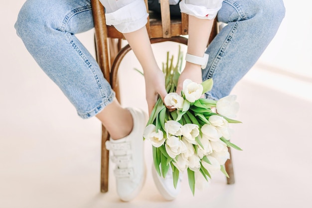 White tulips bouquet in woman's hands. Flower market owner photo shoots