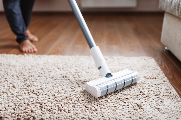 A white turbo brush of a cordless vacuum cleaner on the carpet. Indoor cleaning concept