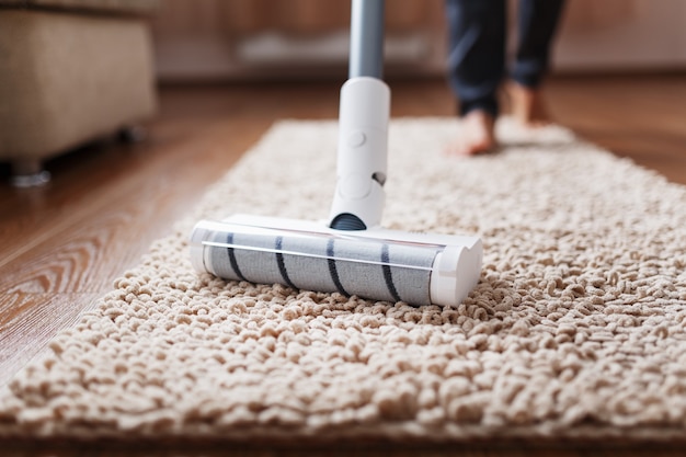 A white turbo brush of a cordless vacuum cleaner on the carpet. Indoor cleaning concept