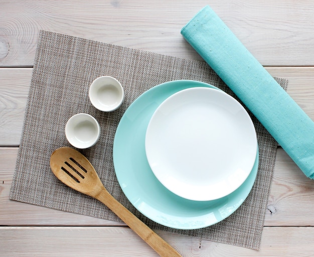 White and turquoise plate, wooden kitchen spoon